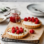 Deliziosi tartellette alla vaniglia con lamponi e pistacchi.